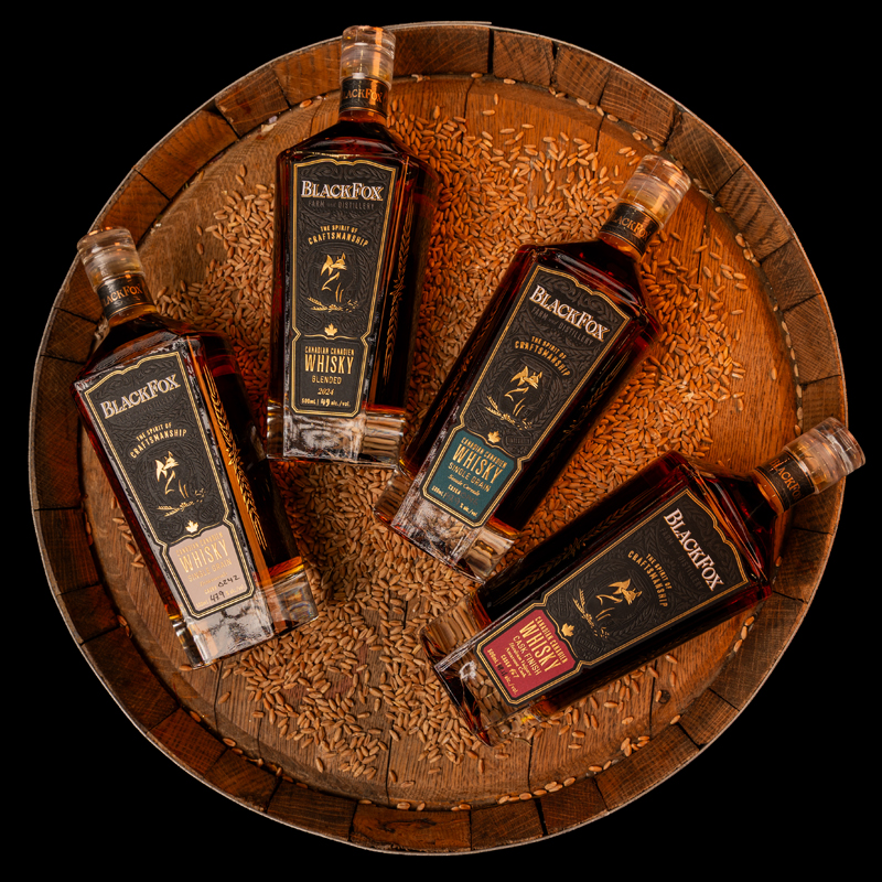 Black Fox Canadian Whisky_800x800 copy A flat lay photo of our Black Fox Canadian Whisky on a signature barrel showcasing our single grain triticosecale, single grain secale cereale, cask finish whisky and blended whisky